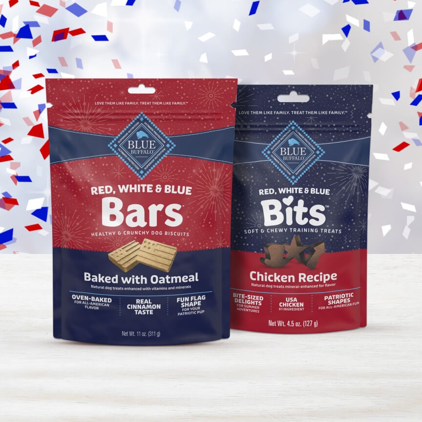 A bag of Blue Buffalo Red, White & Blue Bars and Bits are placed side by side with red, white, and blue confetti cascading down in the background.