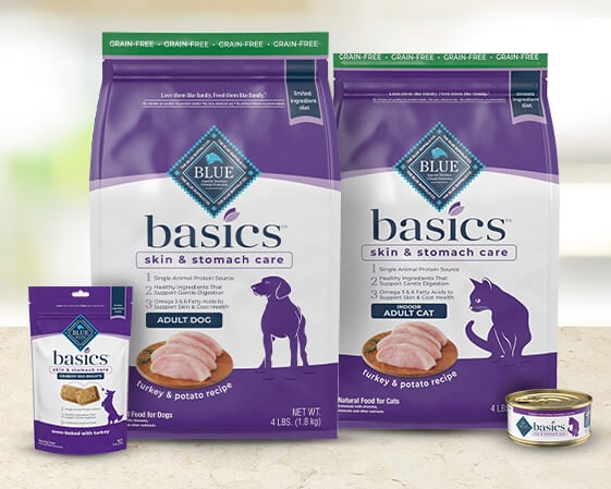 Pet food packaging for Blue Basics skin and stomach care, featuring dry food for adult dogs and cats, and a can of wet food.