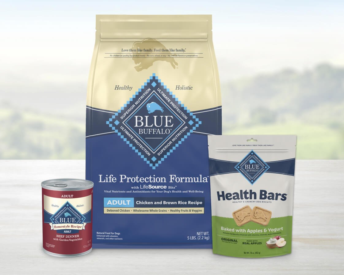 Blue Buffalo dog food and treats, including a dry food bag, canned food, and a pouch of apple yogurt health bars, on display.