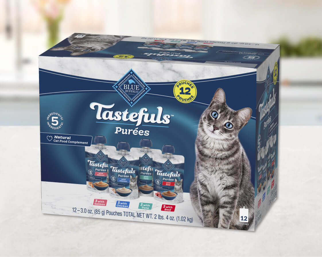 A multi-pack box of Tastefuls Purées in four recipes: salmon, chicken, tuna, and beef is sitting on a white kitchen counter.