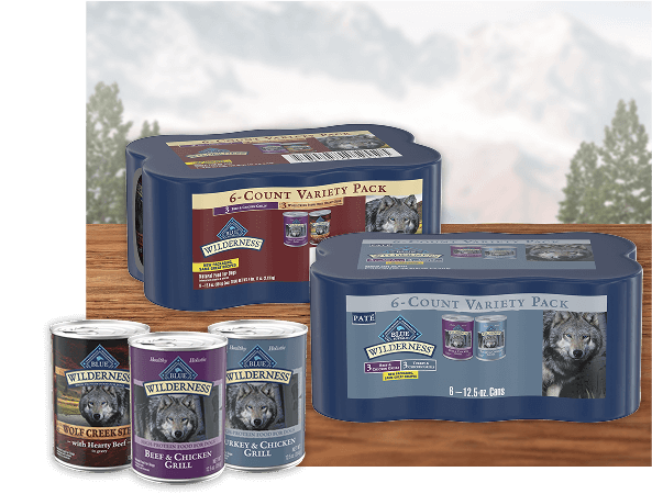 Three cans of wet dog food placed beside an unopened multipack box featuring the same recipes.