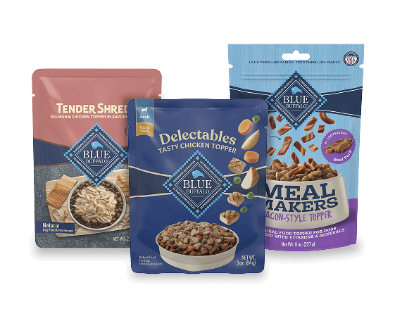 Three Blue Buffalo dog food toppers: Tender Shreds salmon & chicken, Delectables tasty chicken, and Meal Makers bacon-style topper