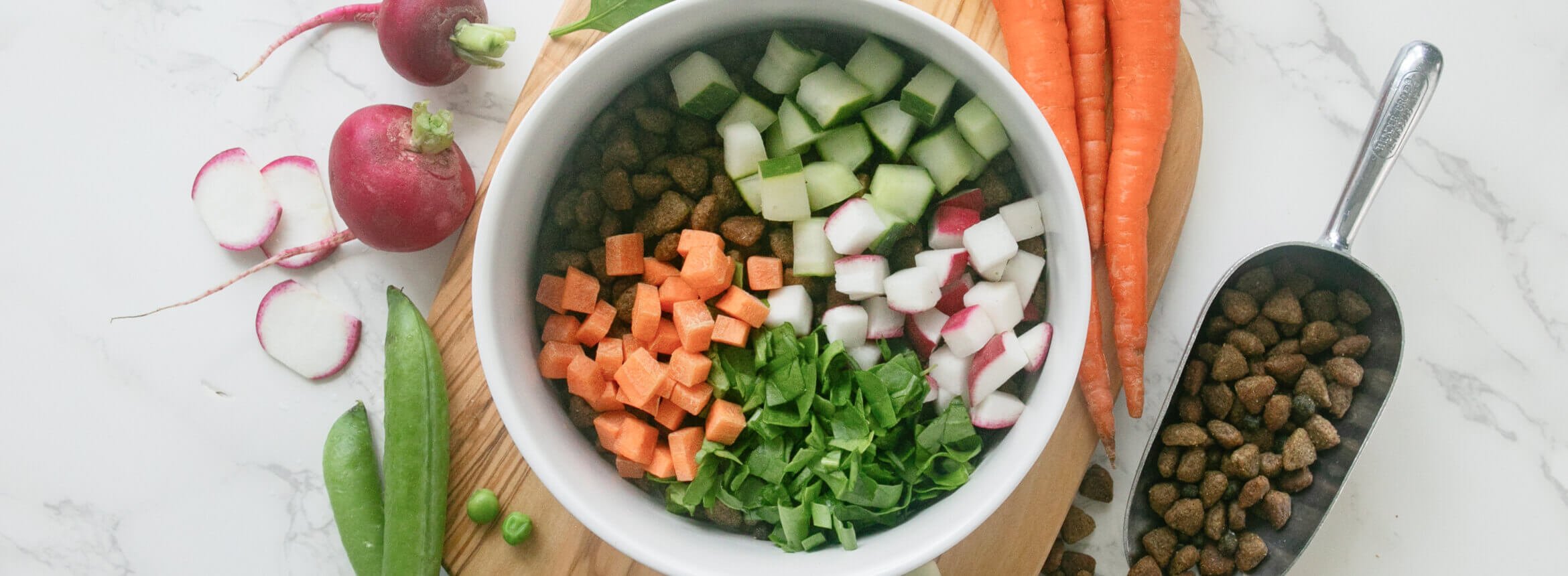 Blue Buffalo Springtime Bowl Recipe for Dogs - A bowl of vegetables and Blue Buffalo Life Protection Dog Food on a cutting board, showcasing a healthy and delicious meal option