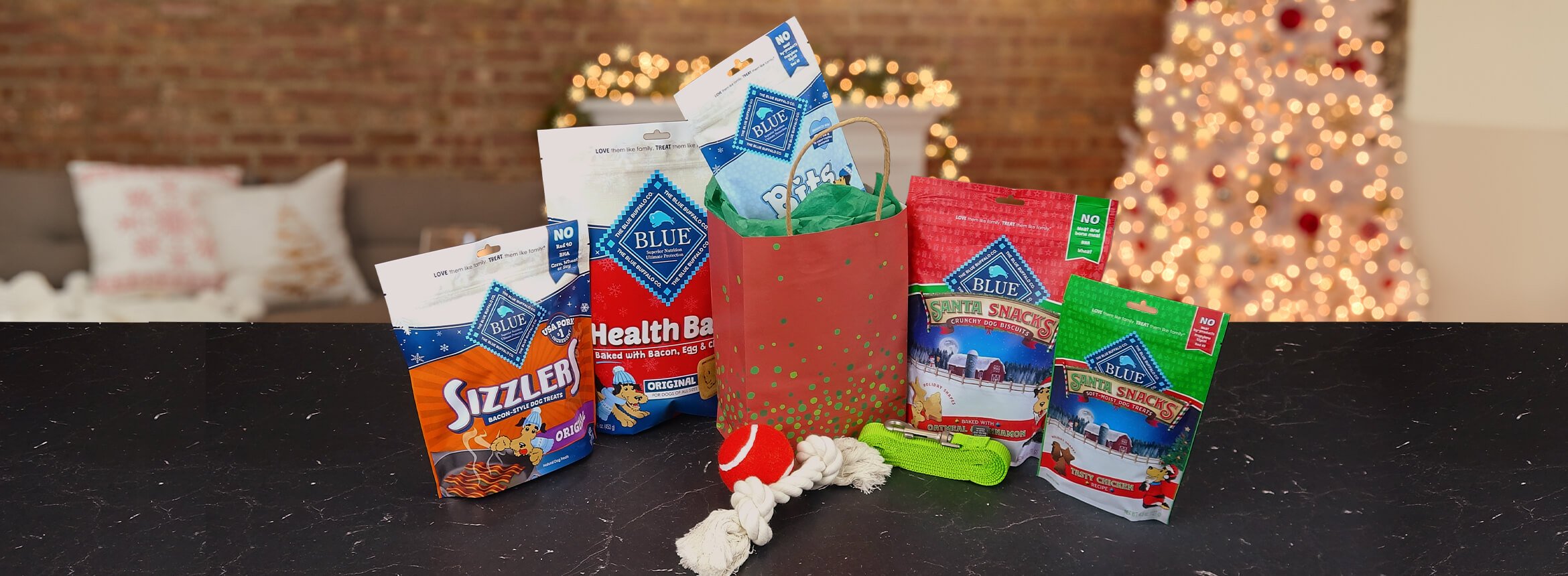 snack bags of dog food and toys with Christmas decorations in the background