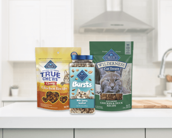 Three Blue Buffalo cat treats: True Chews Chewy Chicken Recipe bag, Bursts With Savory Seafood jar, and Wilderness Chicken & Duck soft treats bag