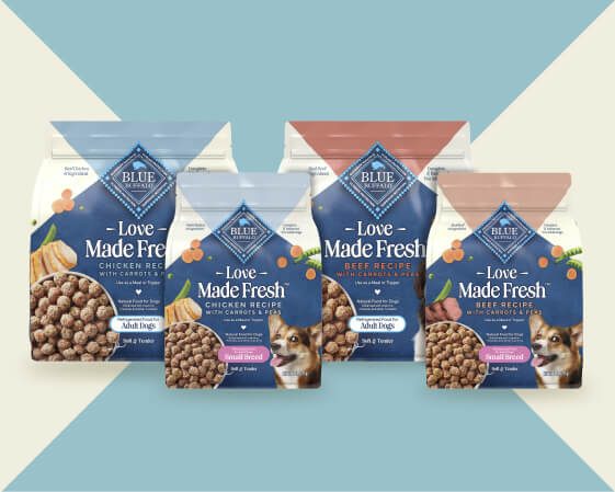 Four bags of Love Made Fresh dog food against a blue and cream geometric background. 