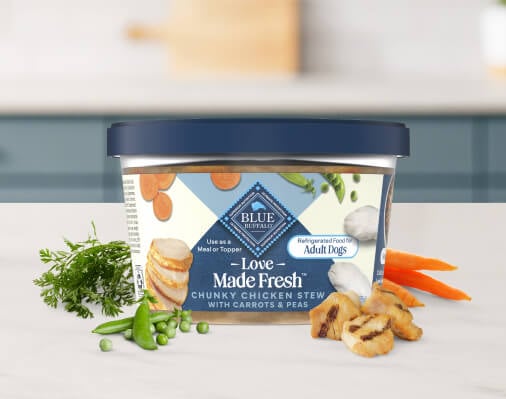 BLUE Love Made Fresh dog food in a tub is pictured against a neutral background. 
