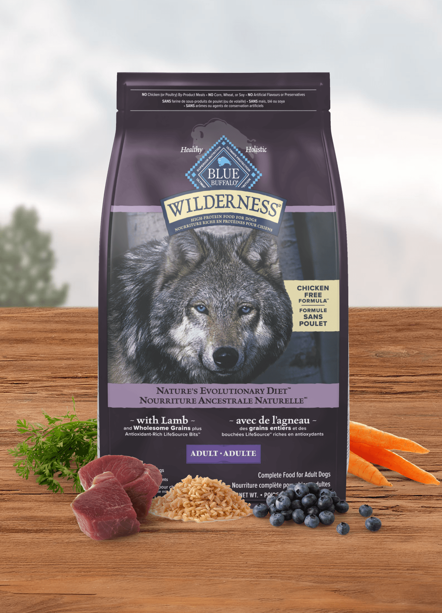 BLUE Wilderness Adult dog food bag with a wolf on the front, displayed with lamb, brown rice, carrots, and blueberries.