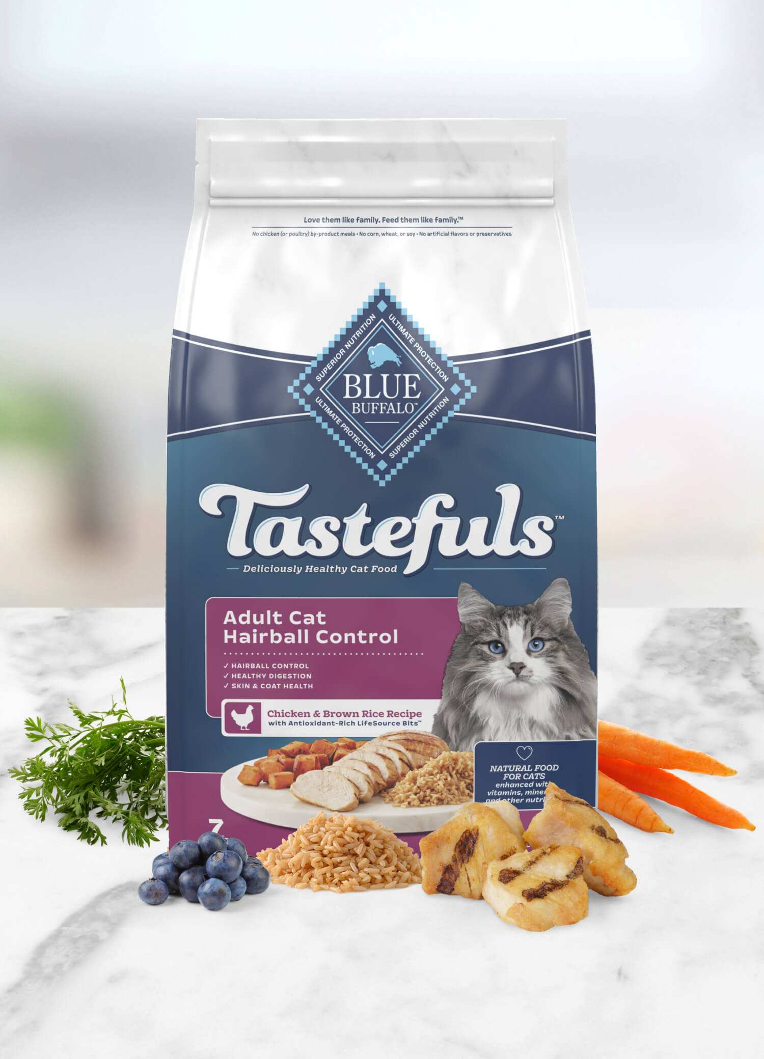 A bag of Blue Buffalo Tastefuls cat food for hairball control, with chicken and brown rice, alongside fresh carrots, blueberries, and parsley.
