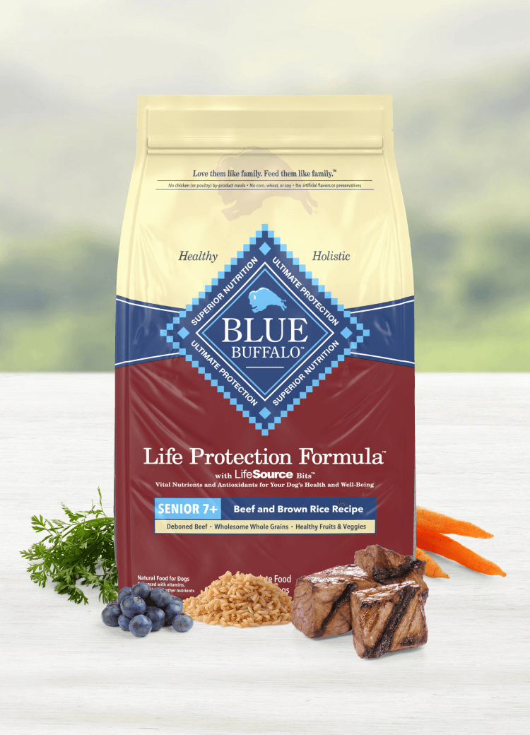 A bag of BLUE dog food shown with tender cuts of beef and real, fresh fruits and vegetables.