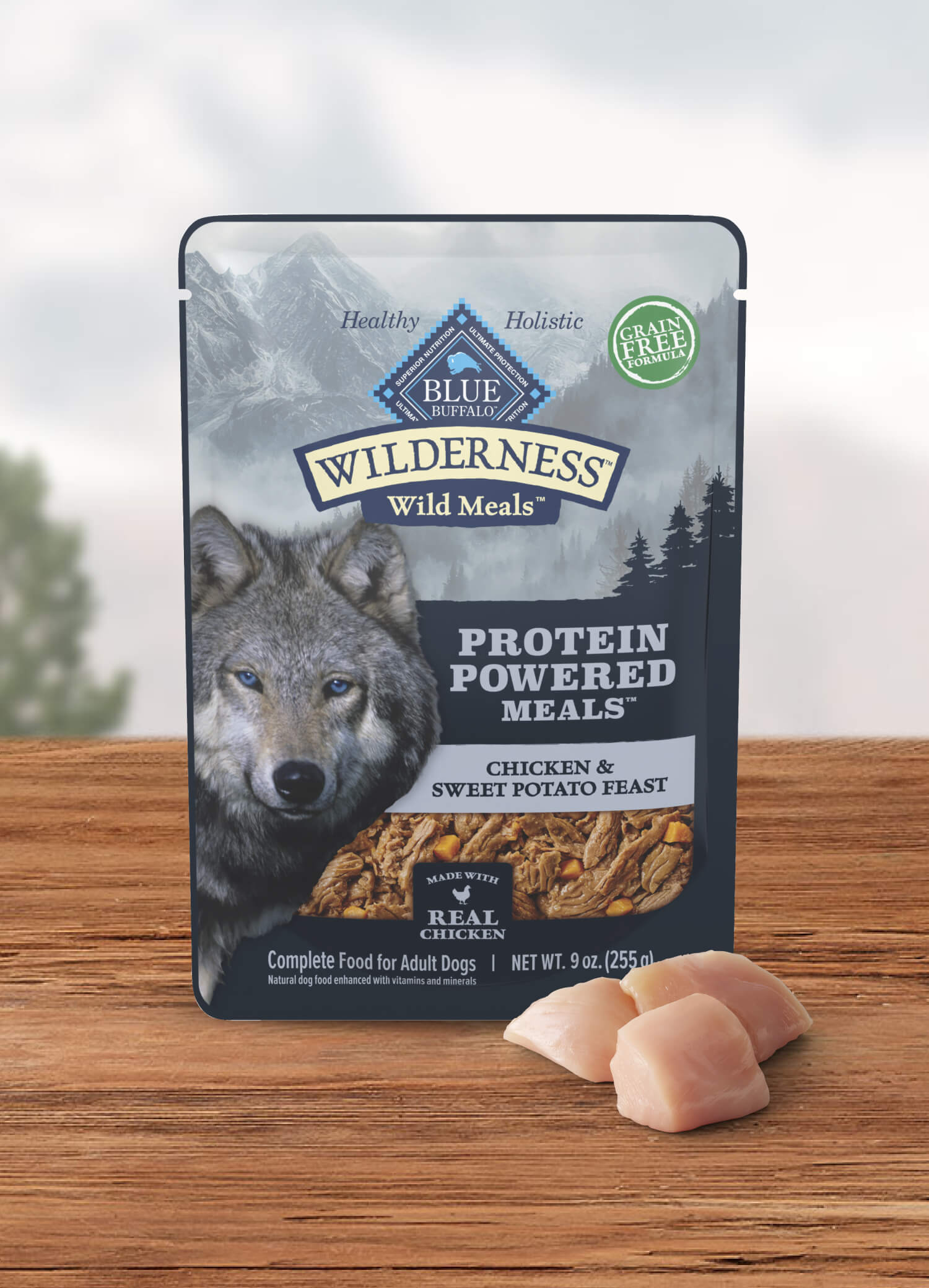 A pouch of BLUE Wilderness Wild Meals and a few cuts of raw chicken.