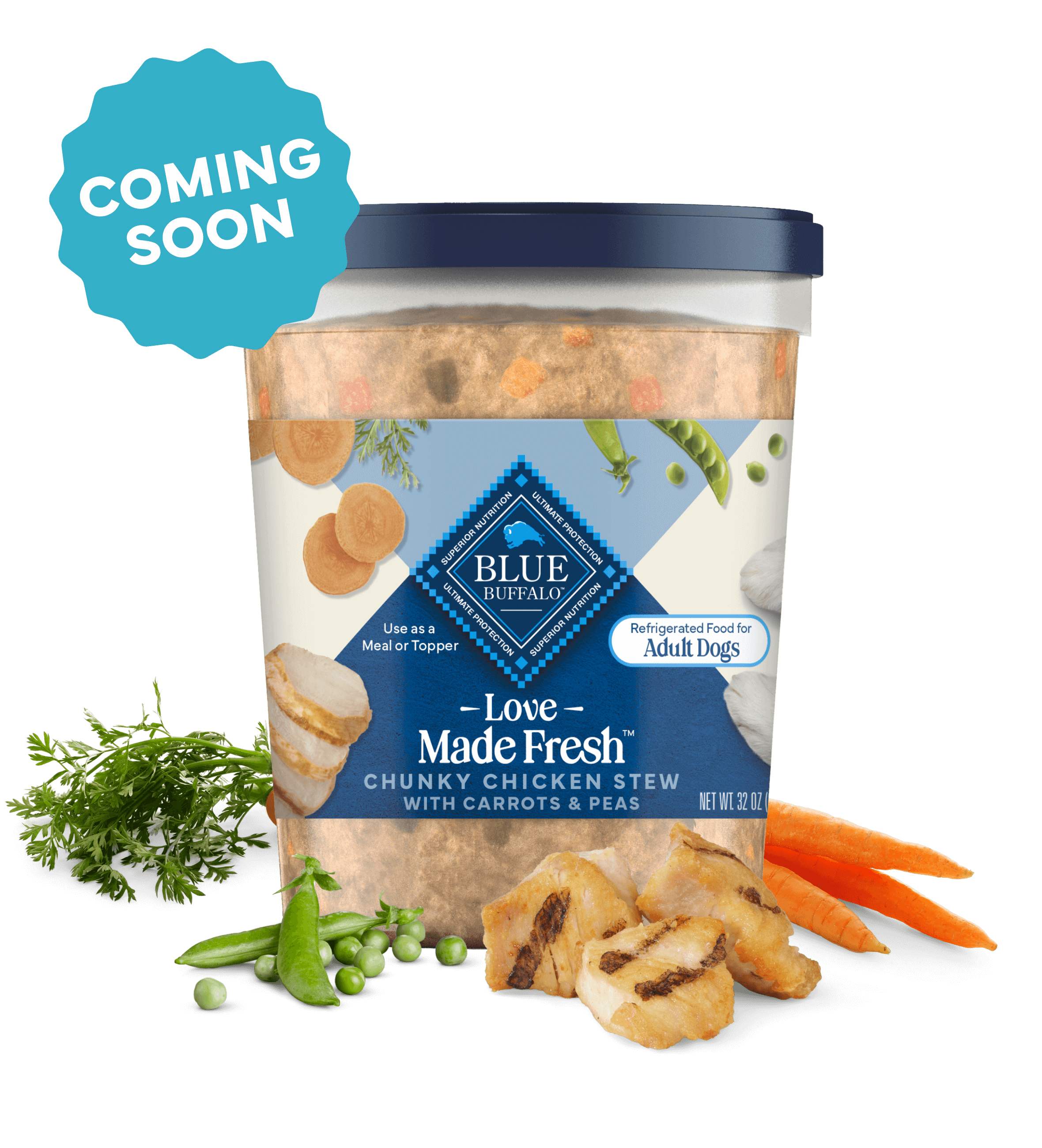 A tub of Love Made Fresh chicken stew is surrounded by parsley, chunks of seared chicken, carrots, and peas on a countertop.
