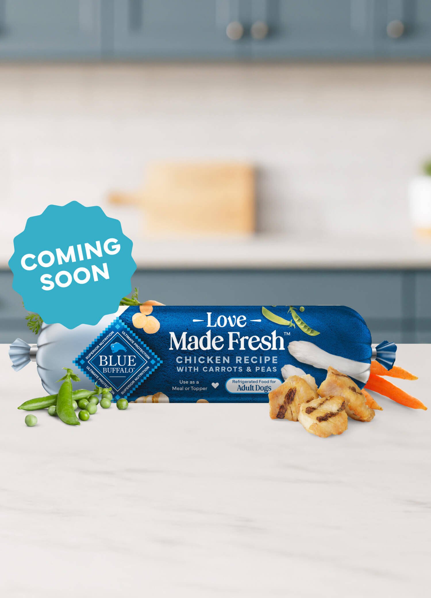 A roll of Love Made Fresh chicken recipe is surrounded by parsley, chunks of seared chicken, carrots, and peas on a countertop.