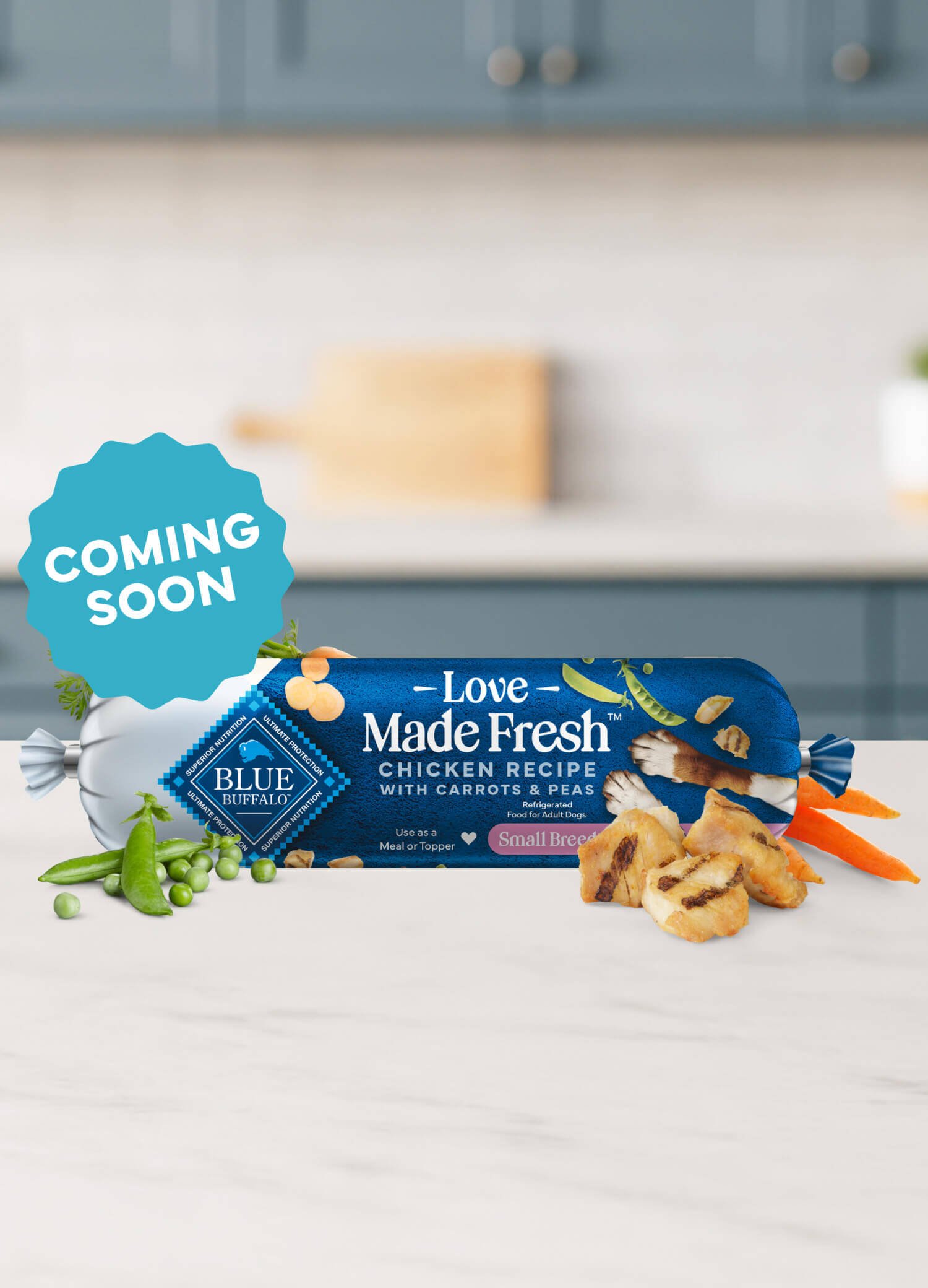 A roll of Love Made Fresh chicken recipe is surrounded by parsley, chunks of seared chicken, carrots, and peas on a countertop.