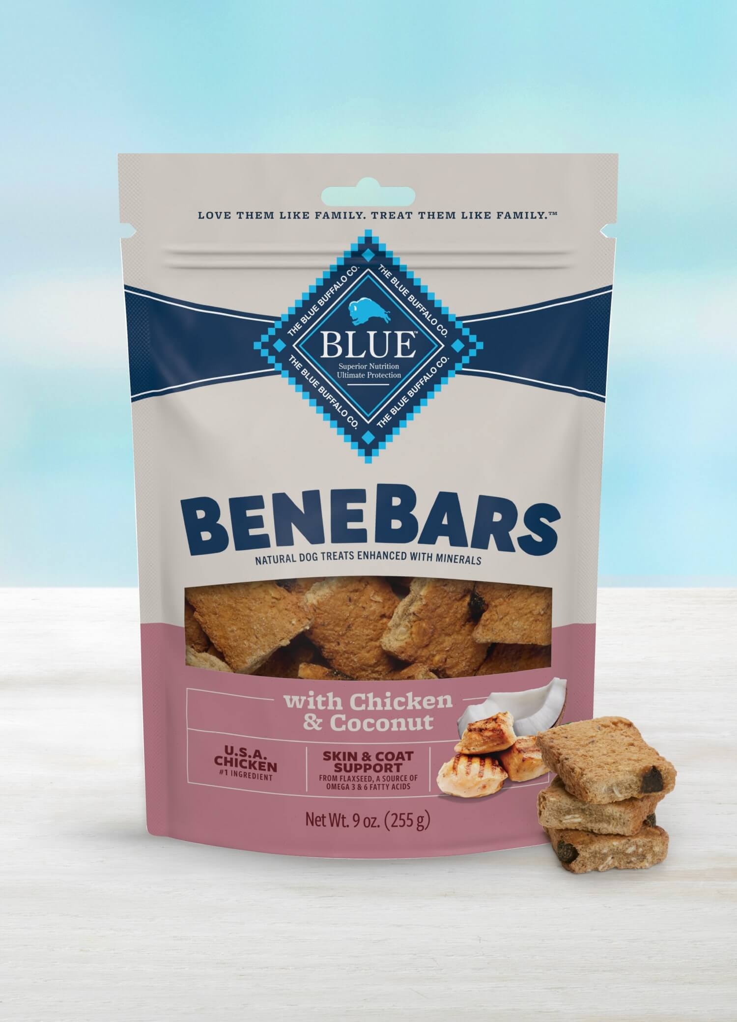 A bag of BeneBars dog treats with chicken and coconut flavor sits on a light surface with treats beside it.