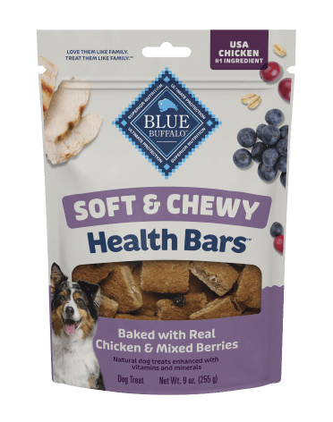 A package of BLUE dog treats shows juicy berries, pieces of tender chicken, and a happy dog. A small stack of treats sits beside the treat bag.