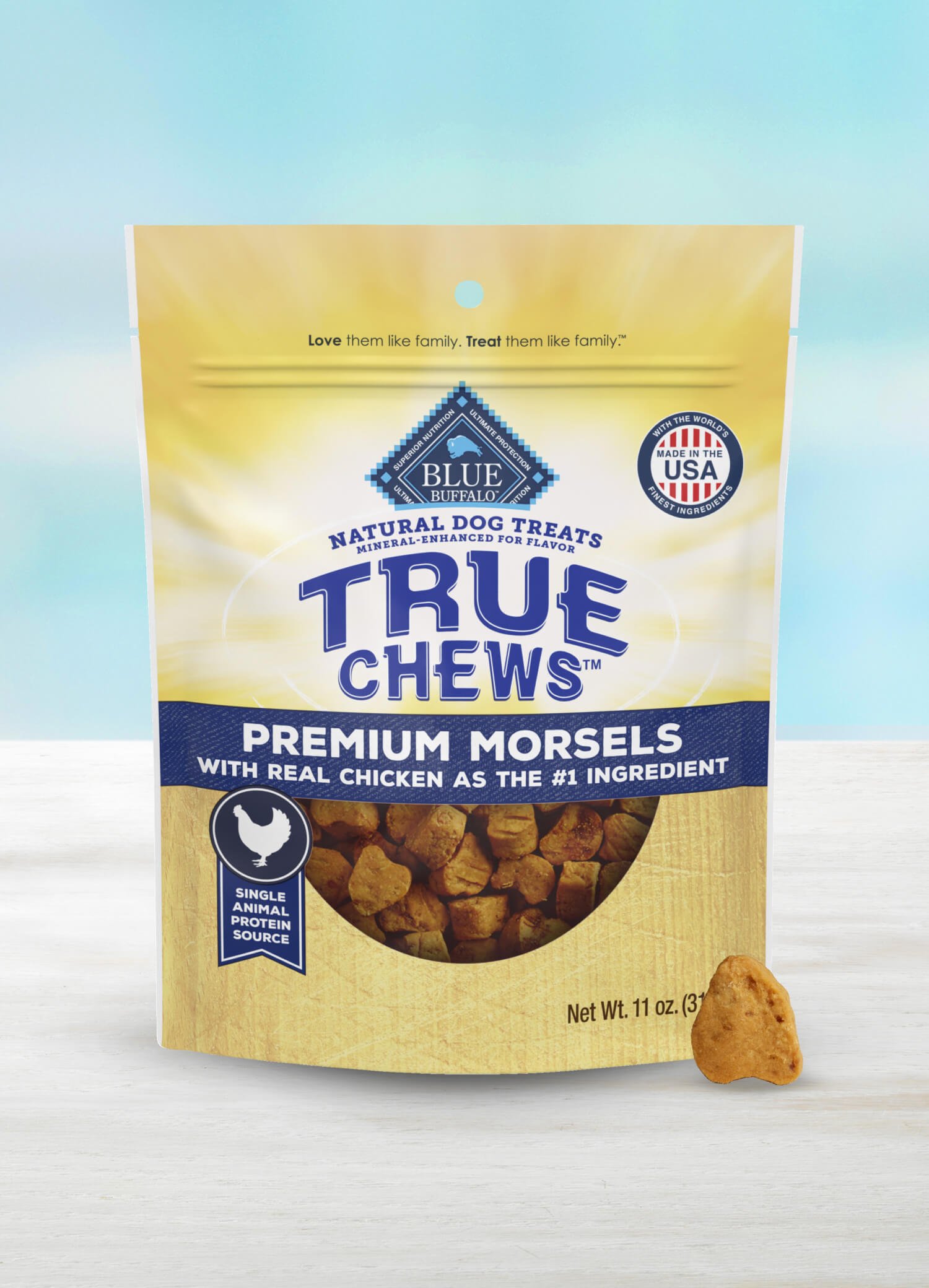 A bag of True Chews Premium Morsels dog treats with a chicken piece in front of the package.