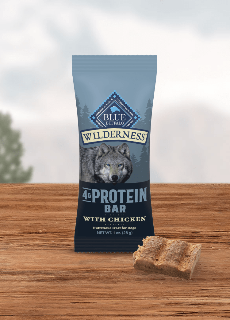 Blue Buffalo Wilderness 4g Protein Bar with Chicken dog treat pouch with a wolf image beside a cut bar piece
